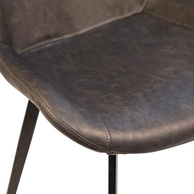 Close-up of a dark leather chair seat with metal legs.