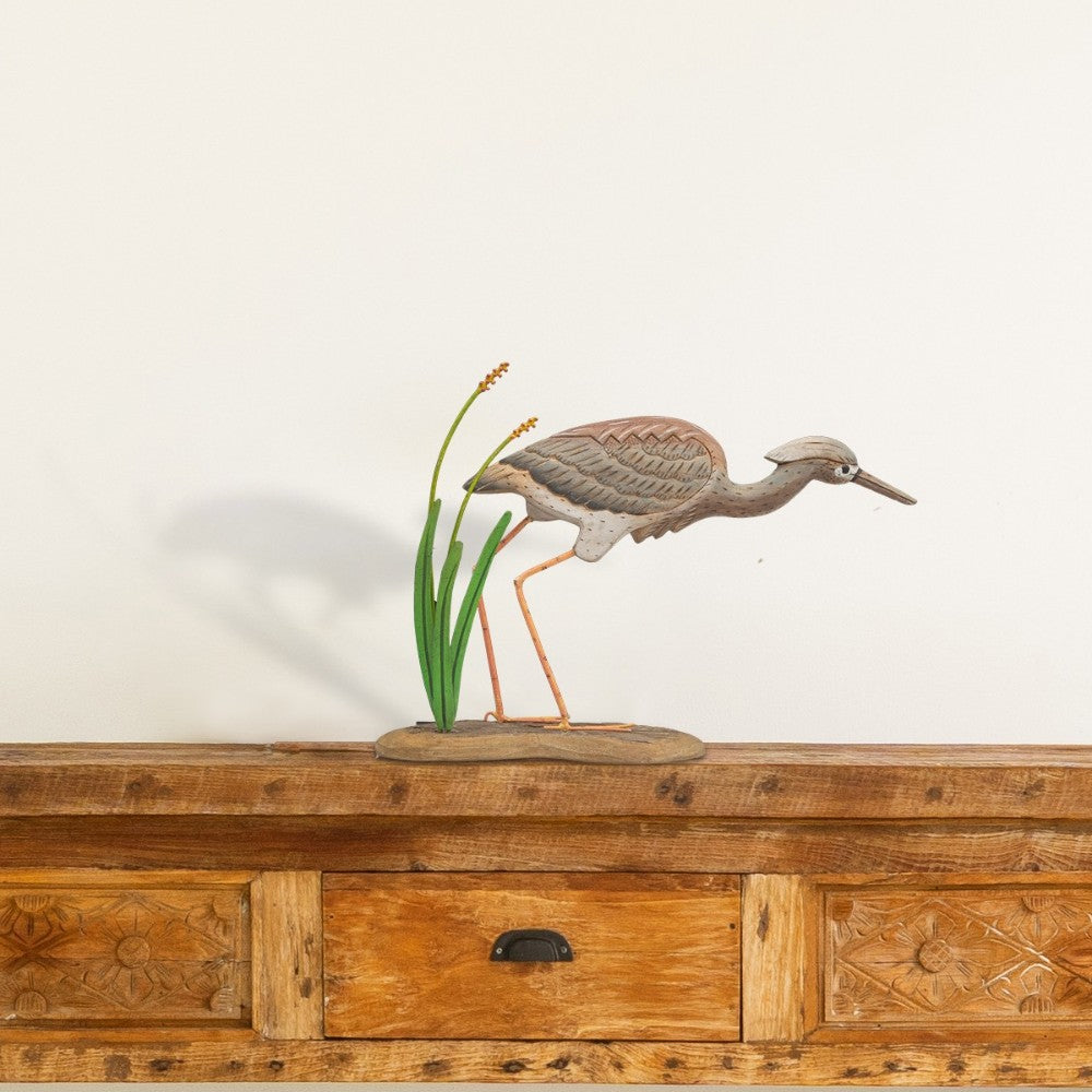 Wooden bird sculpture on a wooden cabinet with intricate carvings.