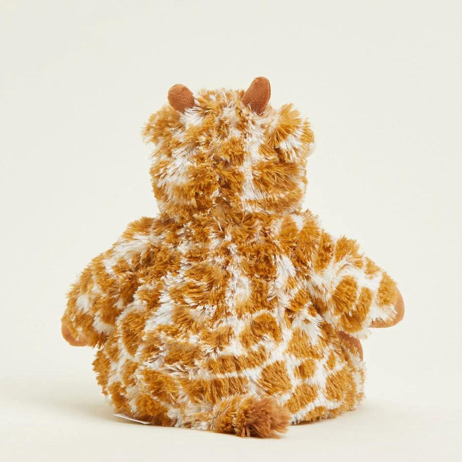 Fluffy giraffe plushie sitting with its back facing.