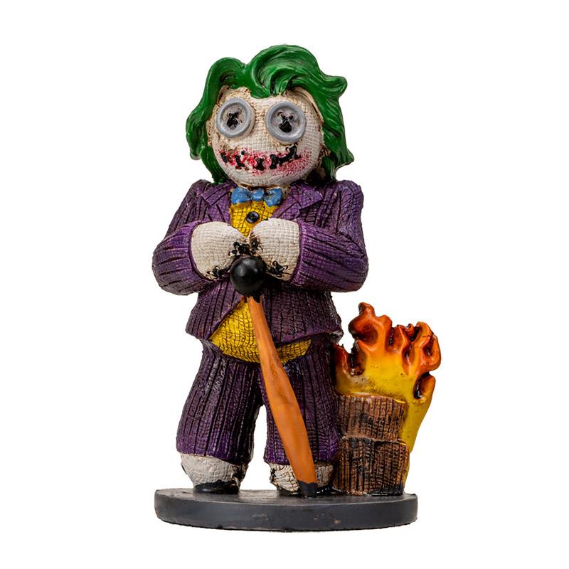 Toy figure with green hair, purple suit, and fire beside it.