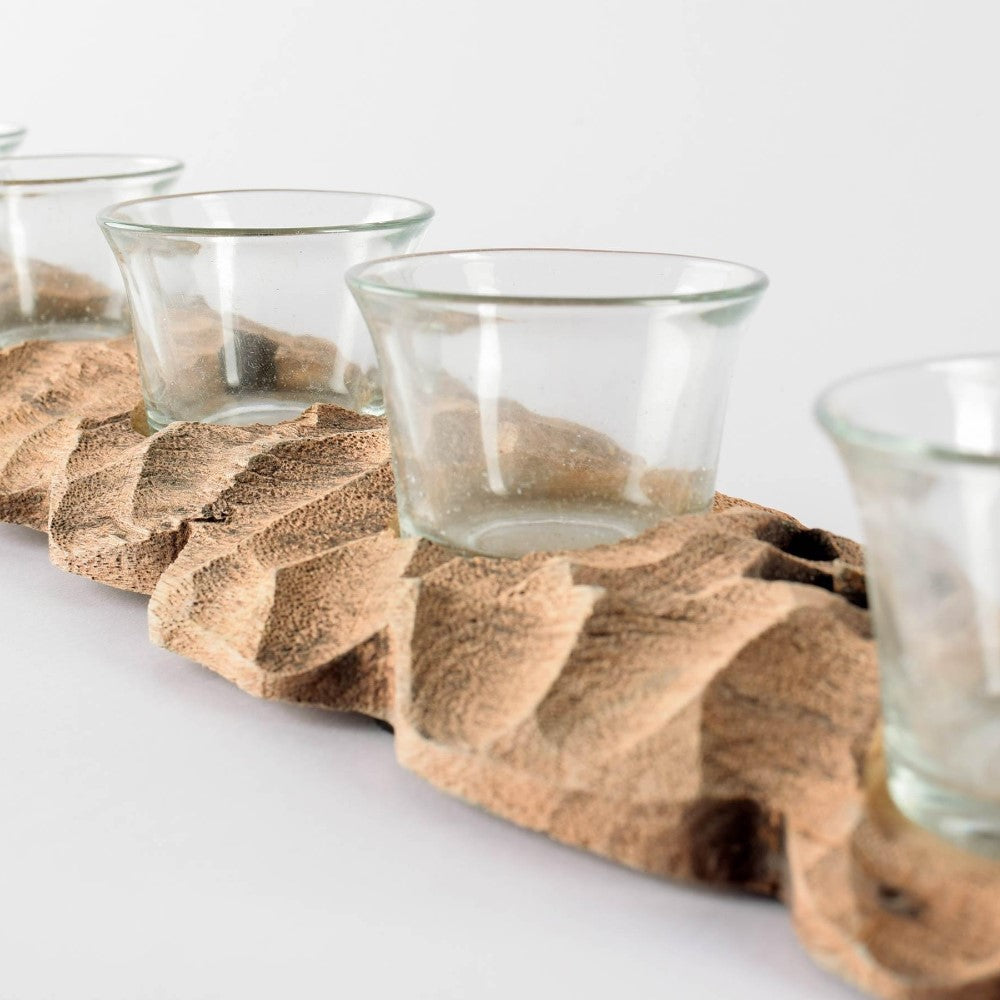 Glass cups on a textured wooden tray.