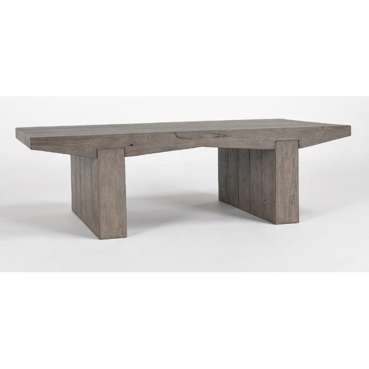 Wooden table with slab design and two thick, rectangular legs.