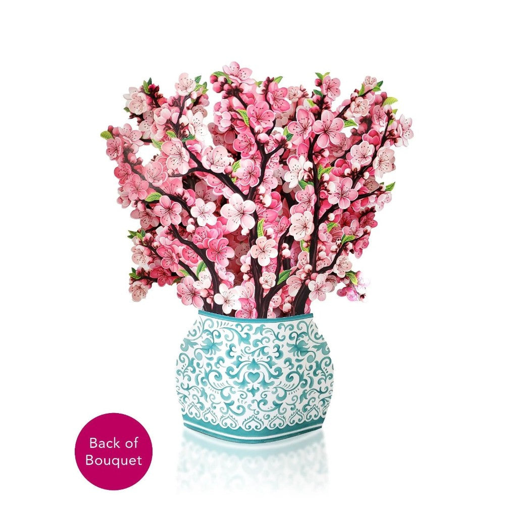 Pink cherry blossoms in a decorative vase.