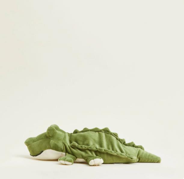 Green crocodile plush toy on a light background.
