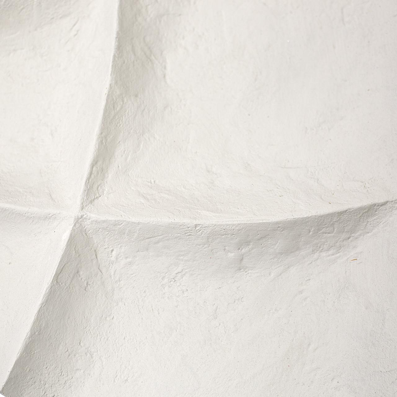 Textured white surface with curved, intersecting seams.