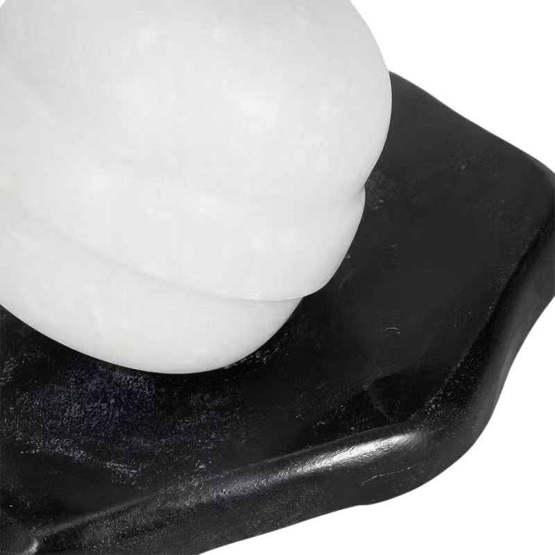 White marble sculpture on a black base.