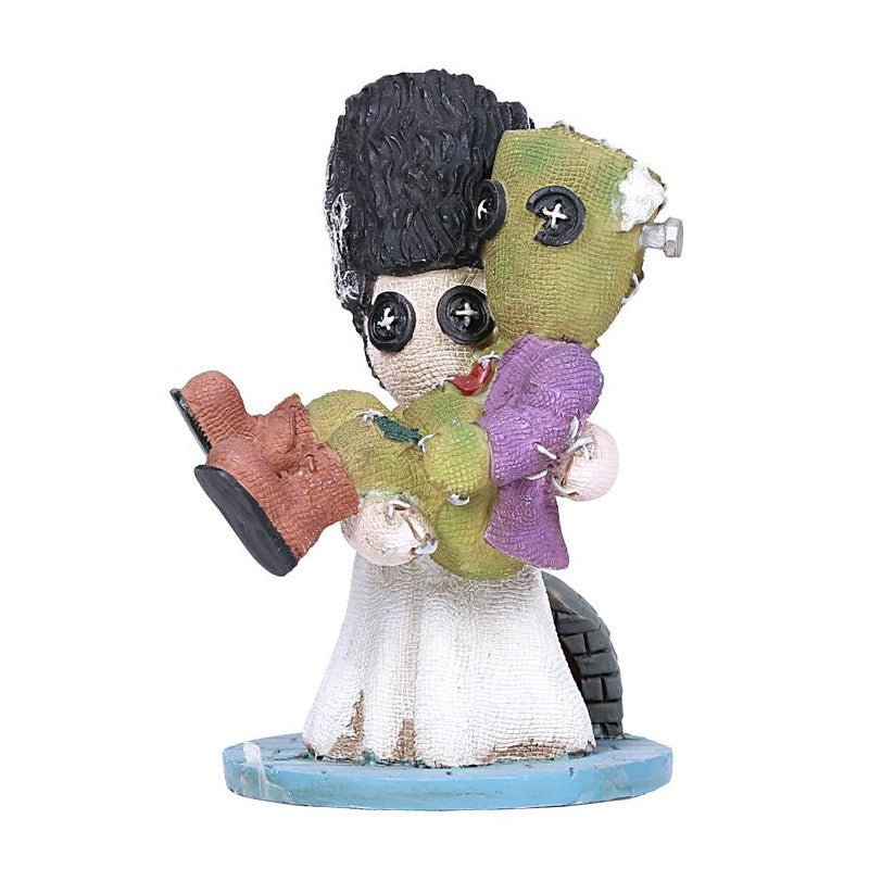 Two button-eyed rag dolls hugging each other.