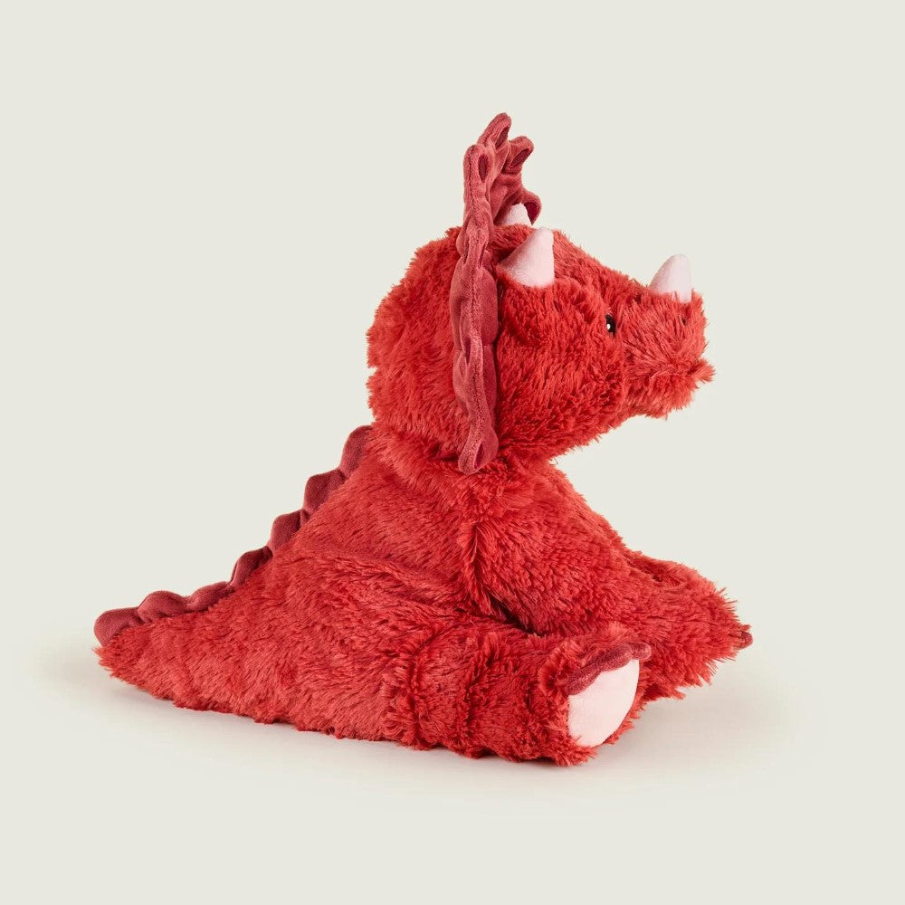 Red dinosaur plush toy sitting sideways on a light background.