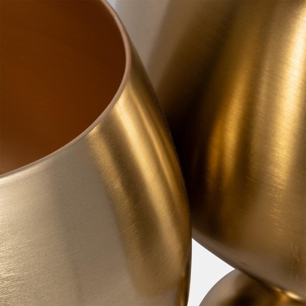 Close-up of two metallic, brushed gold objects with a smooth texture.