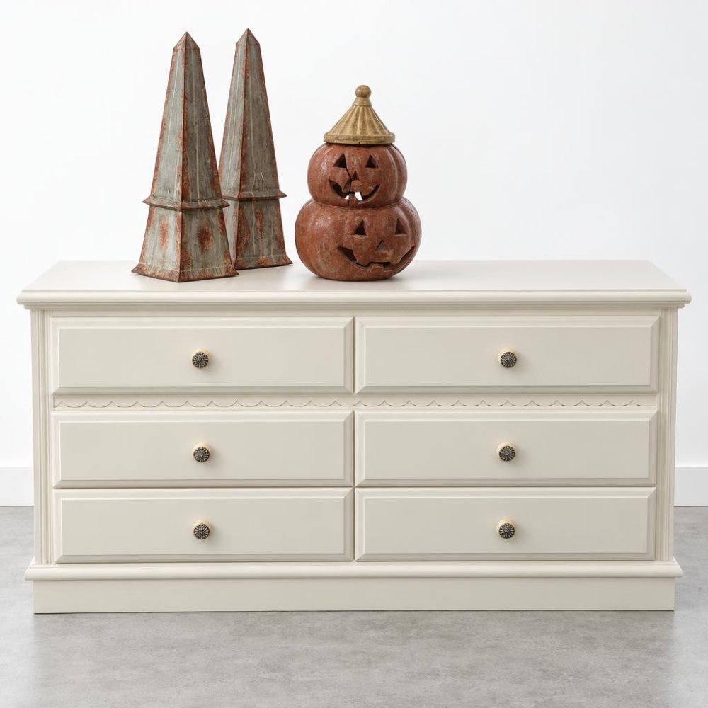 Cream dresser with Halloween decorations on top.