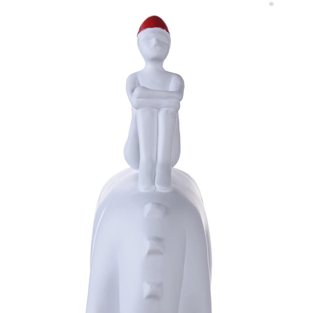 White figure with red hat sitting on a smooth, curved surface.