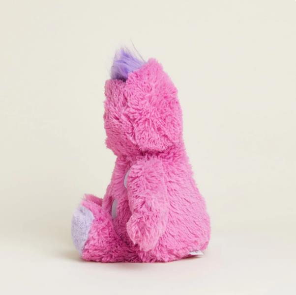 Pink stuffed bear with purple accents sits against a light background.