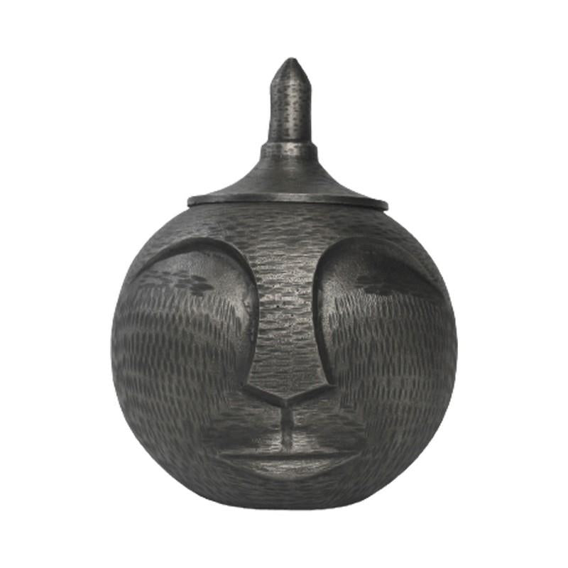 Sculpted round jar with a serene face and pointed lid.