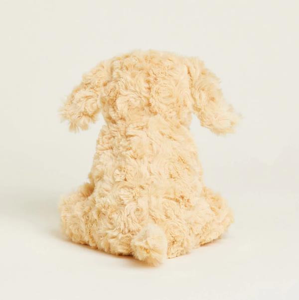 Fluffy beige stuffed toy dog sitting, back view.