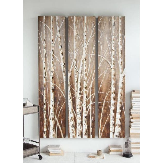 Triptych of birch trees on wood panels with books and a cart nearby.