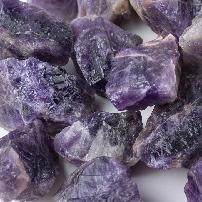 Close-up of raw purple amethyst crystals clustered together.
