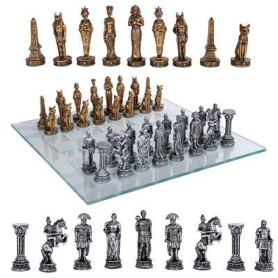 Egyptian-themed chess set with bronze and silver pieces on a glass board.