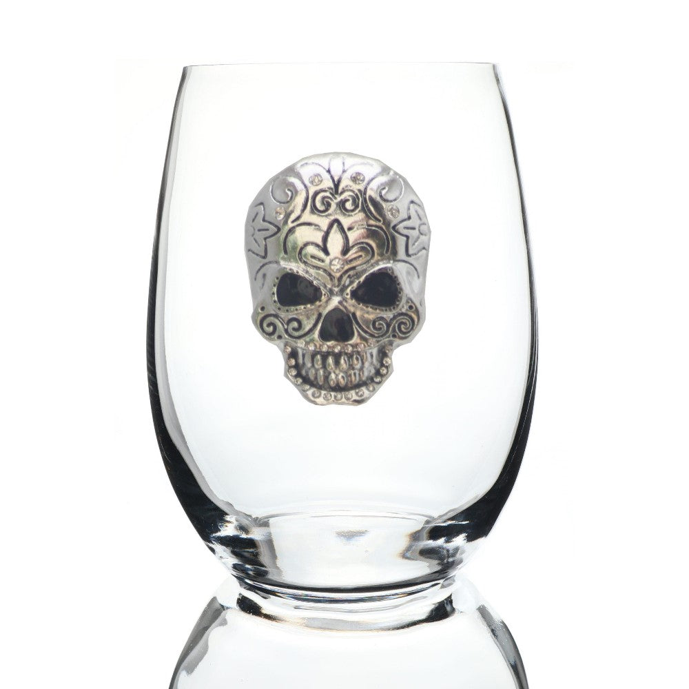Clear glass with an ornate silver skull design on it.