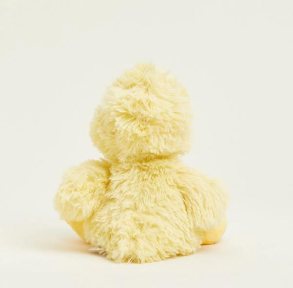 A fluffy, yellow duck plush toy facing away.