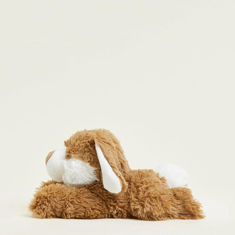 Fluffy brown stuffed dog lying on a light background.