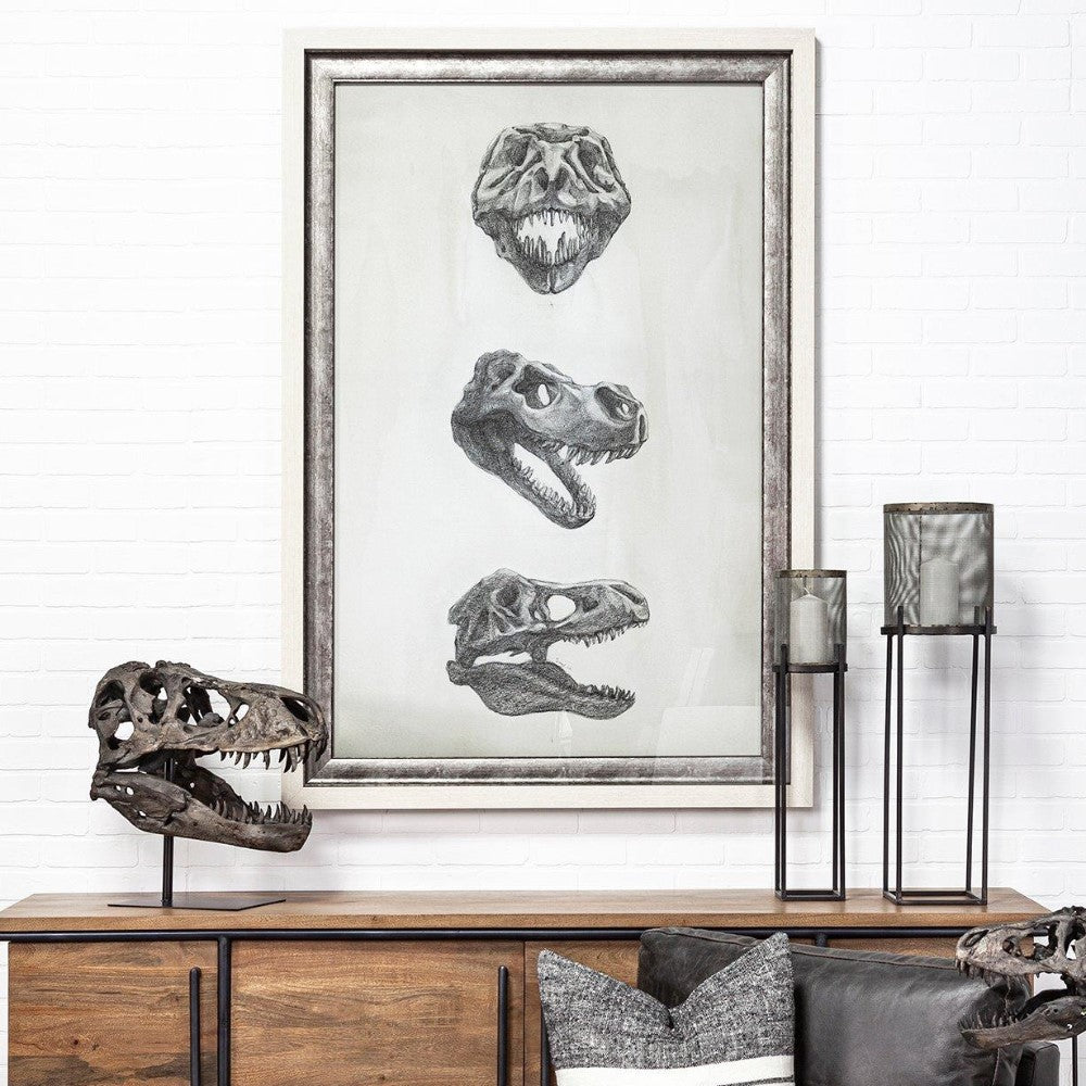 Dinosaur skull art and decor on a wooden sideboard.