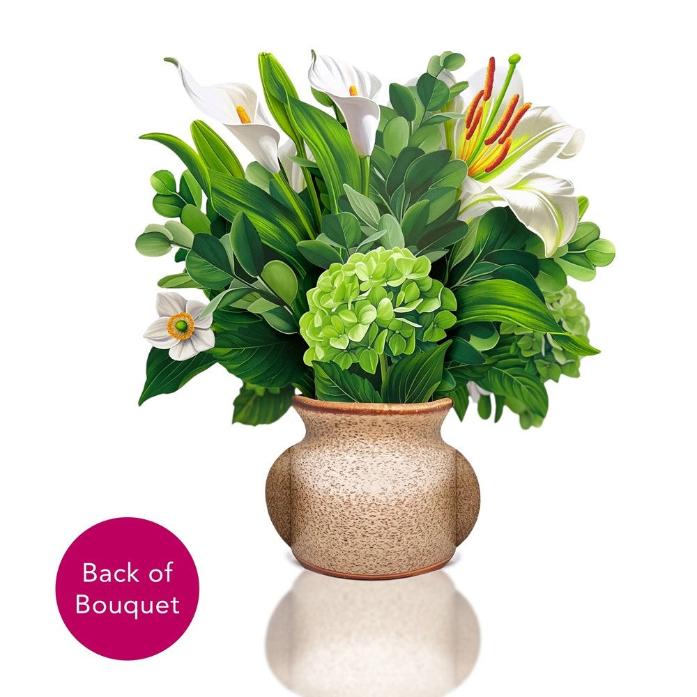 Vibrant bouquet with white lilies and lush greens in a textured vase.