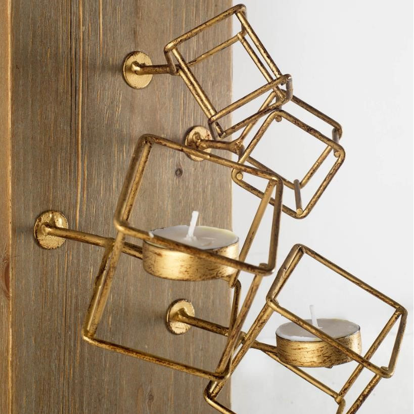 Gold geometric wall sconce with tealight holders.