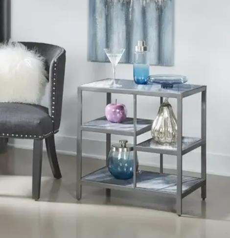 Modern side table with decor items, next to a gray chair with a fluffy pillow.