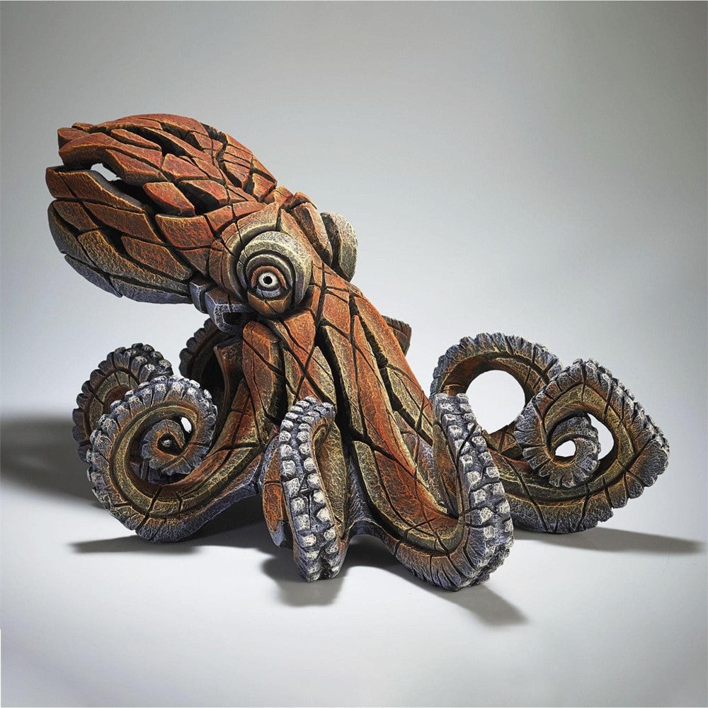 Wooden octopus sculpture with intricate carvings and swirling tentacles.