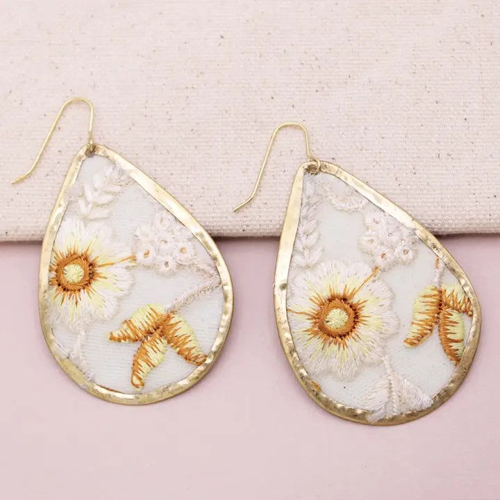 Teardrop earrings with floral embroidery and gold-tone borders.