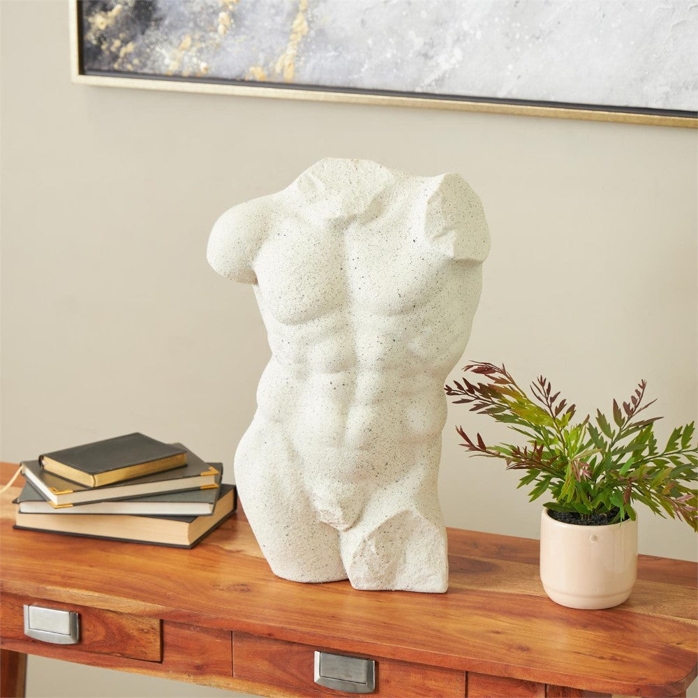 White torso sculpture, books, and plant on a wooden desk.