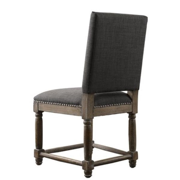 Wooden chair with dark padded back and seat, nailhead trim, and turned legs.