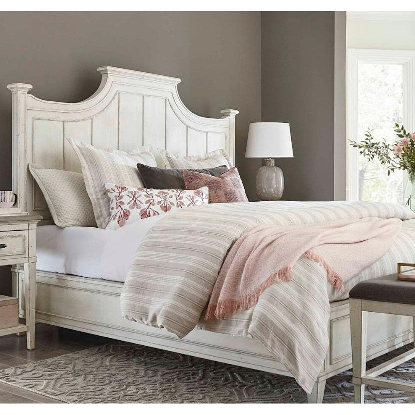 Cozy bedroom with a rustic bed, soft bedding, and a stylish lamp.