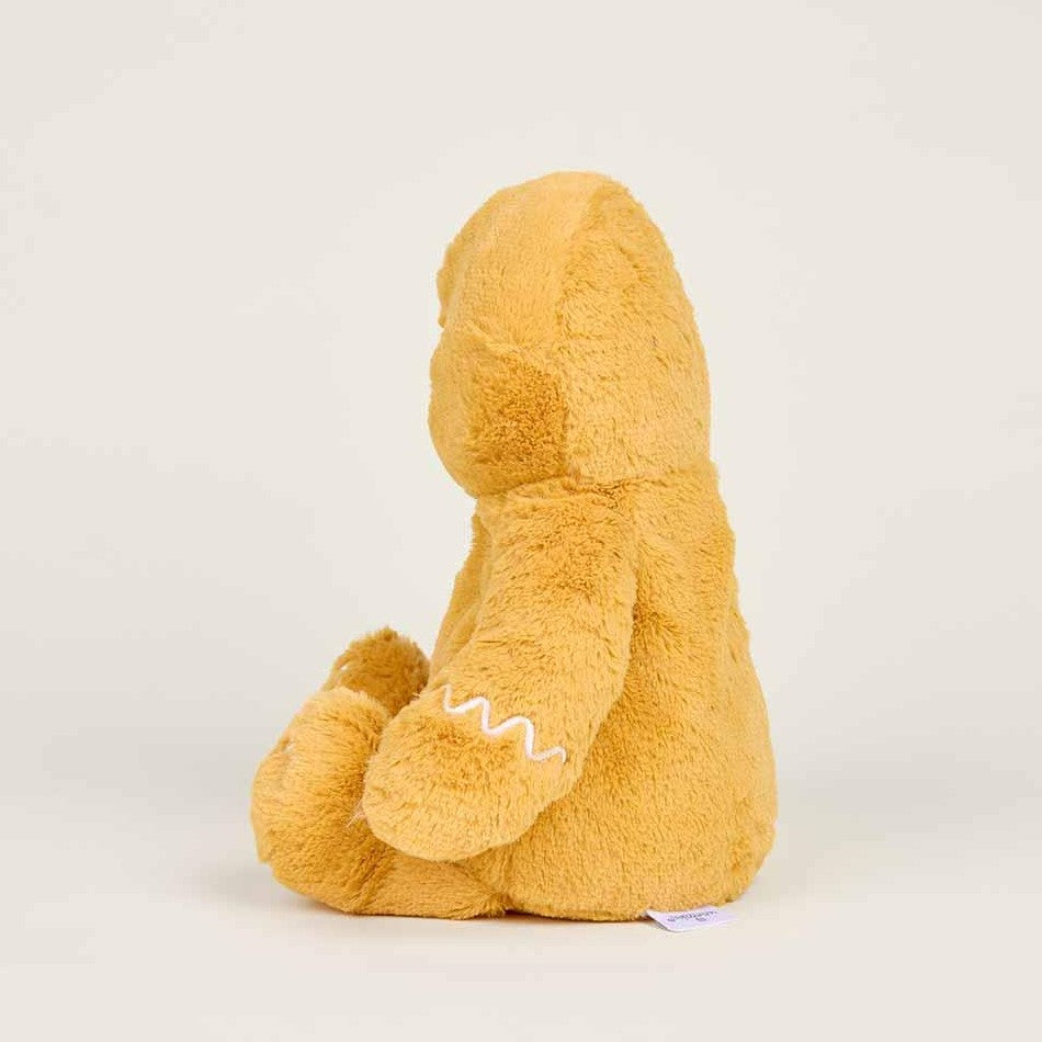 Brown plush toy sitting against a plain background.