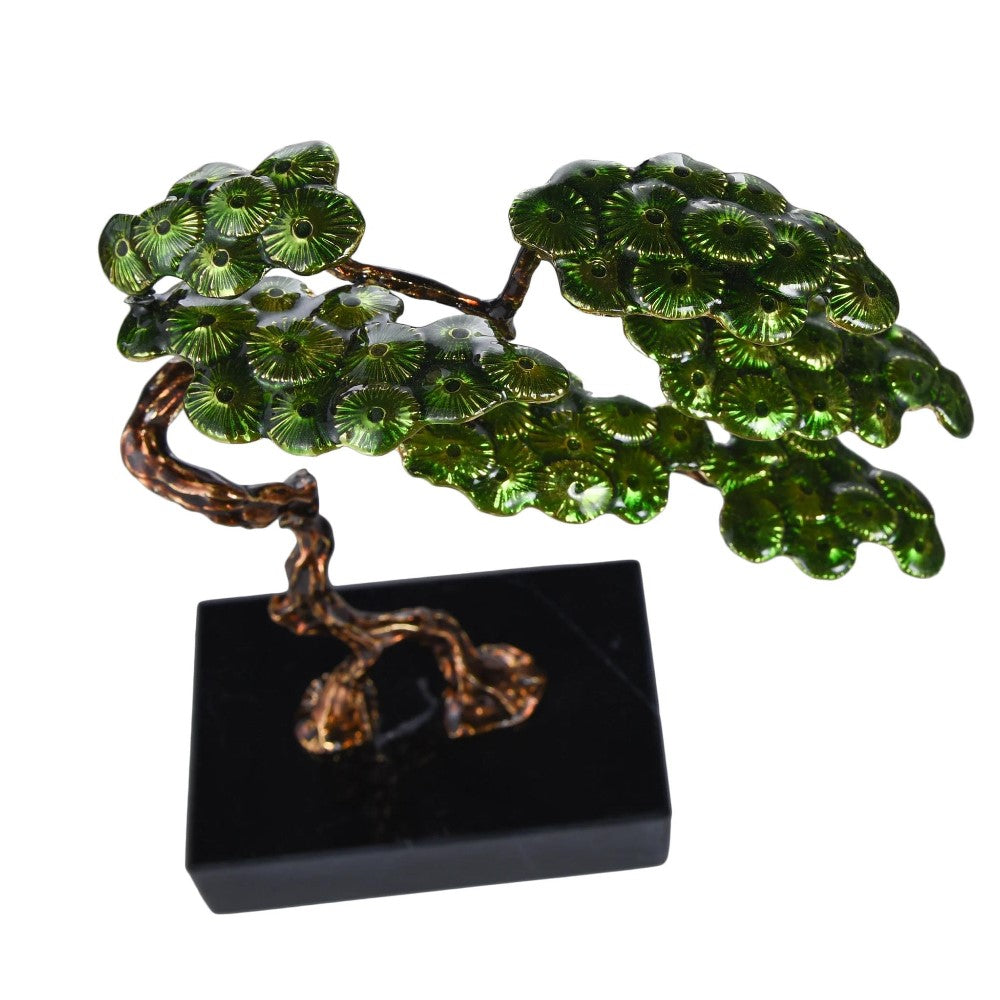 Metallic bonsai tree sculpture with green leaves on a black base.