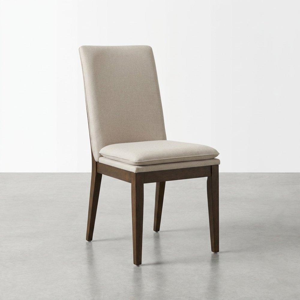 Beige cushioned chair with dark wooden legs on concrete floor.