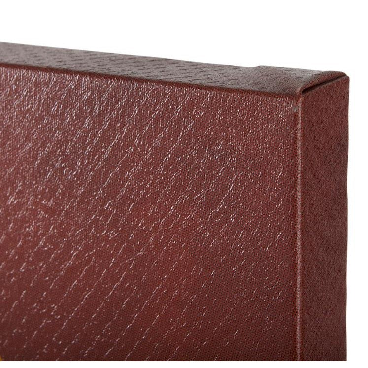 Close-up of textured brown-red corner, possibly a book or box.