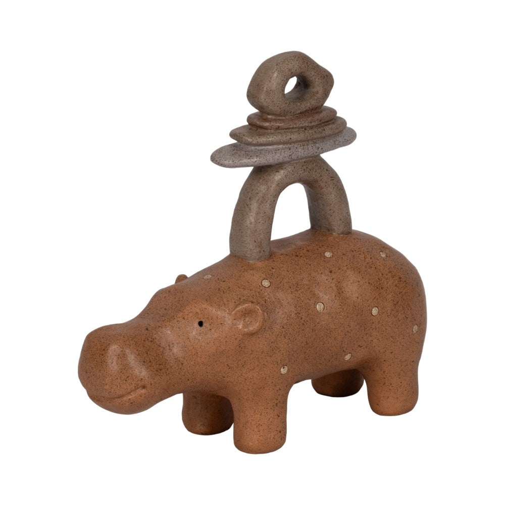 Clay hippo figurine with stacked stone rings on its back.