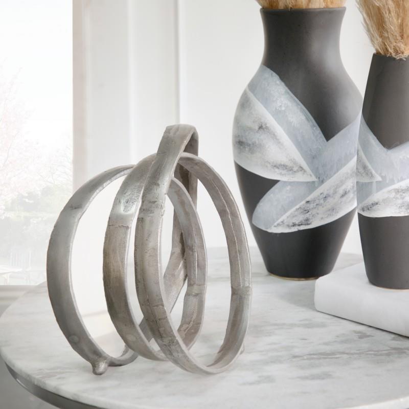 Metal rings and vases on a marble table.