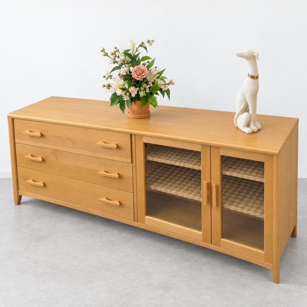 Wooden sideboard with drawers, plant, and dog sculpture.