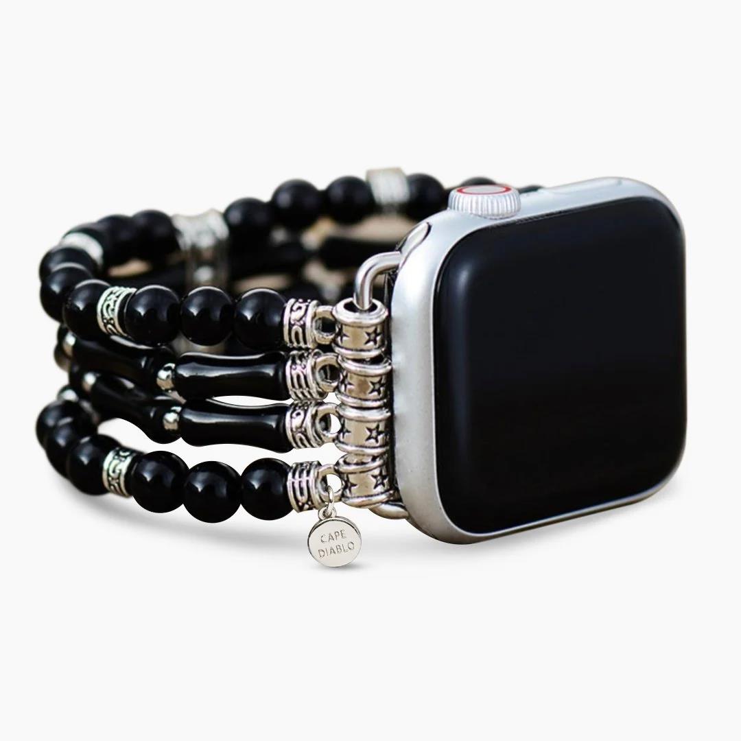 Smartwatch with black beaded band and decorative silver elements.