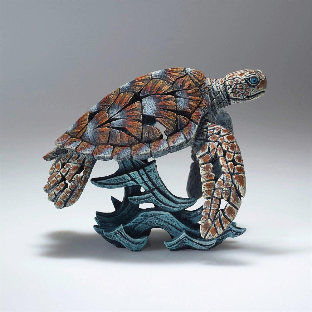 Colorful mosaic sea turtle sculpture on a wave.