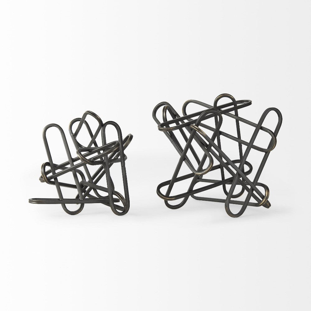 Intertwined black wire sculptures against a plain background.