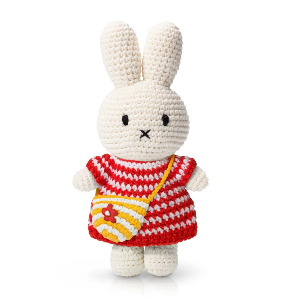 Crocheted white bunny in a red striped dress with a yellow bag.
