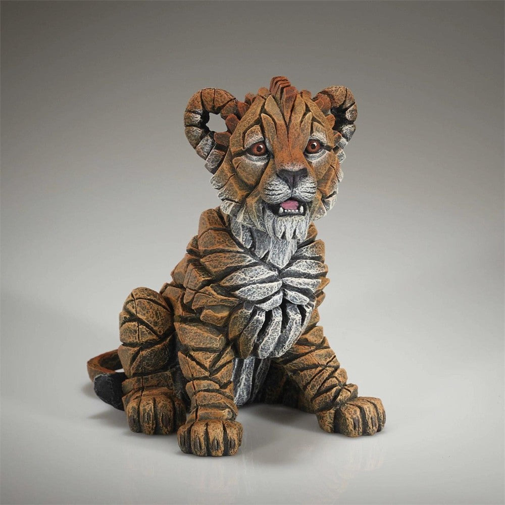 Sculpted stone tiger cub with layered textures.