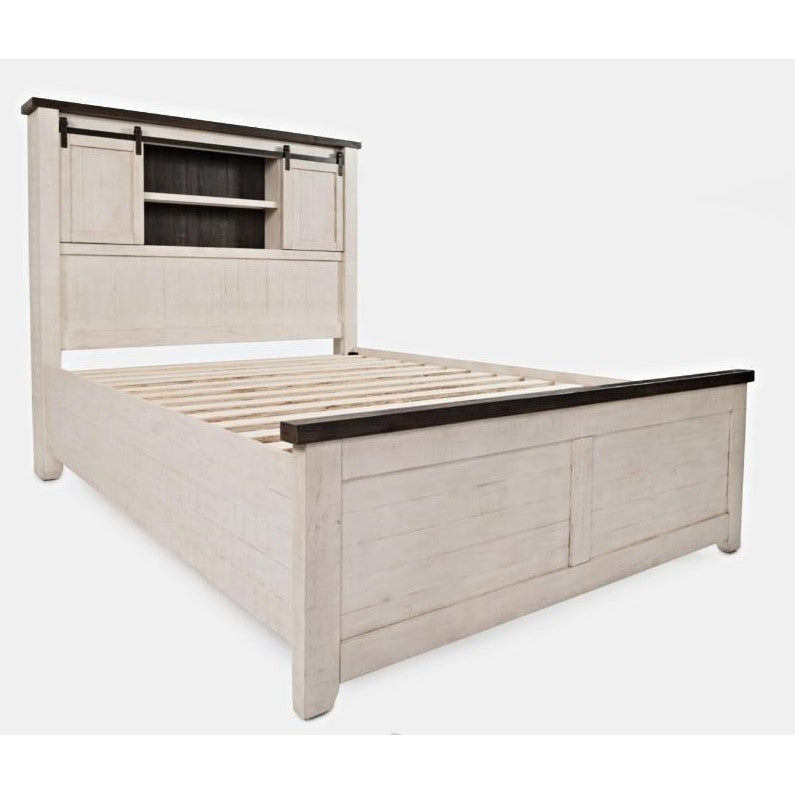 White wooden bed with a headboard featuring sliding barn doors.