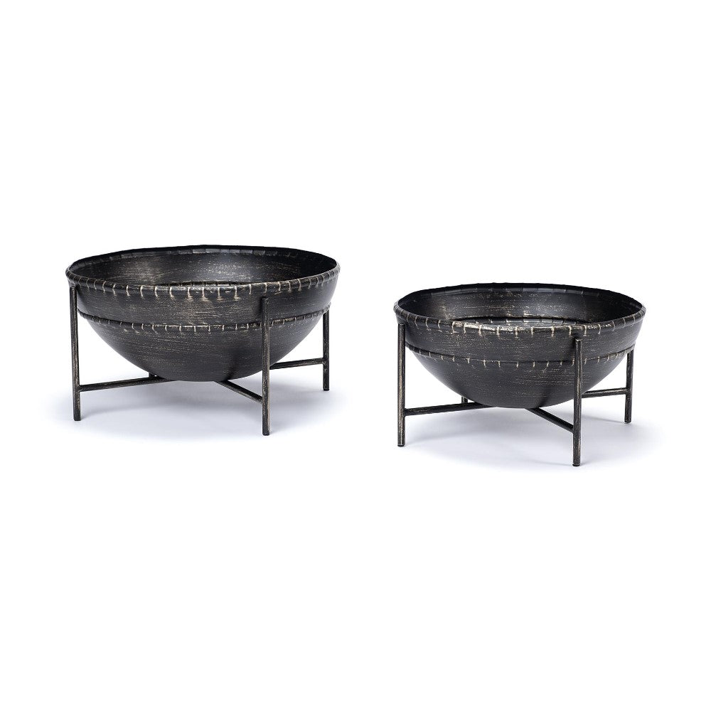 Two black metal firepits on stands, one larger than the other.