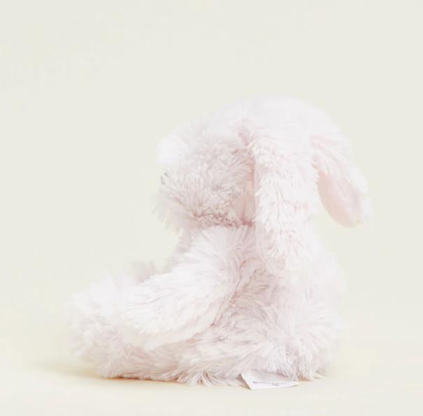 Fluffy white plush rabbit sitting sideways.