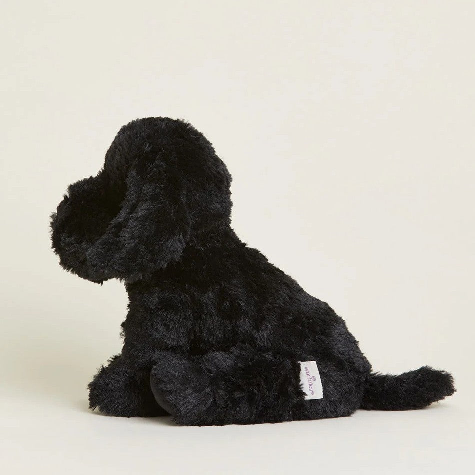 Fluffy black stuffed dog sitting sideways.