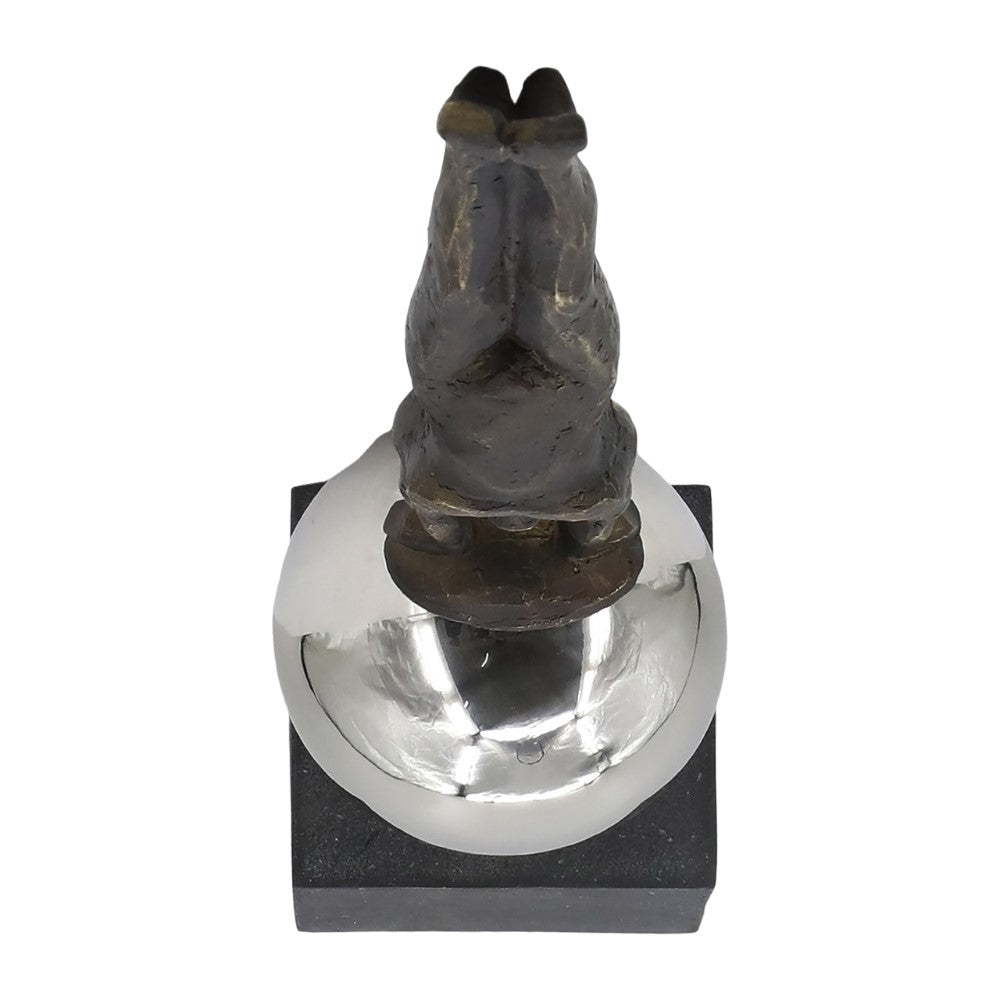 Bronze figurine atop a reflective spherical base on a square platform.